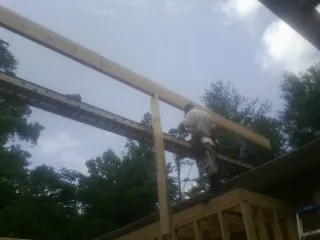 Carpenter setting a ridge beam over a new addition frame — Ice Dam Removal by Roofing Brothers in East Hampstead
