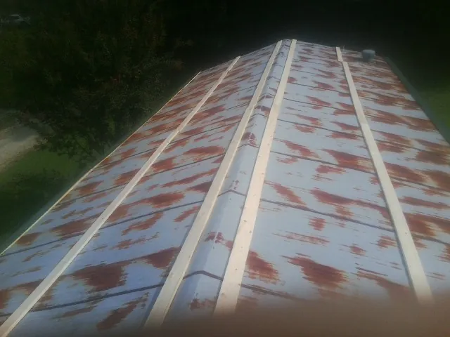 Rusted metal roof panels with new wood purlins before replacement — Storm Damage Roof Repair in East Hampstead by Roofing Brothers