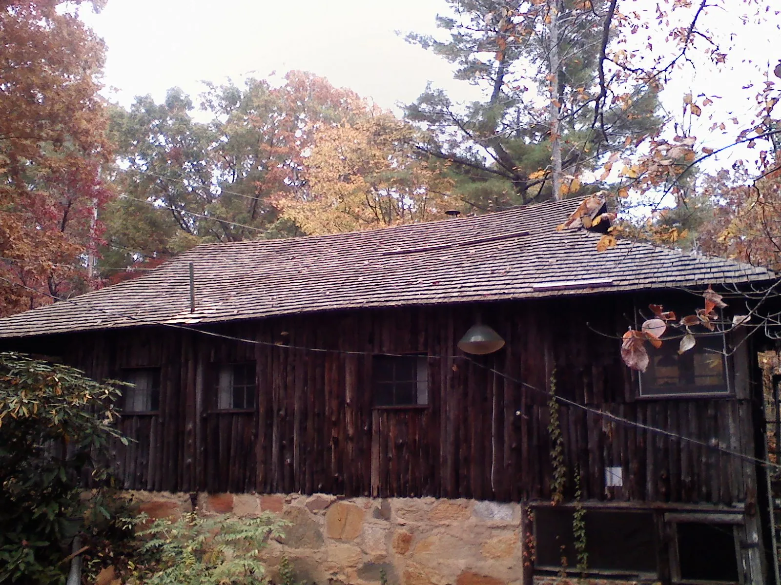 Weathered wood shake roof on a rustic board sided cabin in East Hampstead